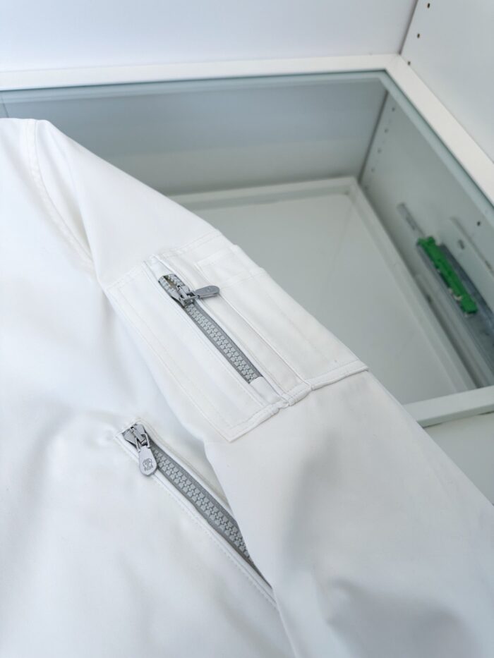 Giacca bianca moderna con tasca a zip sulla manica, stile minimalista e versatile.