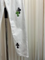 Jeans bianchi slim con dettagli a croce artistici, stile moderno e originale.