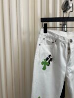 Jeans bianchi moderni con grafiche artistiche green e nere, stile streetwear e moda contemporanea.
