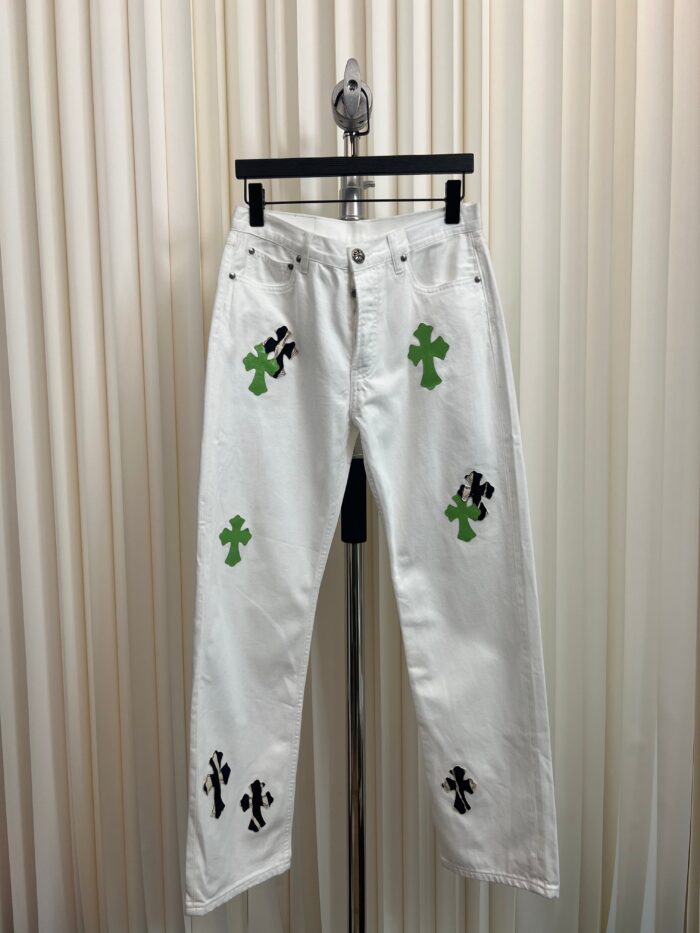 Jeans bianchi con ricami di trifoglio verdi e motivi artistici neri, stile casual e innovativo.