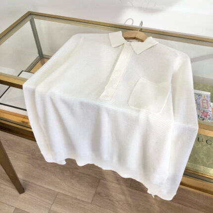 Camicia bianca elegante su tavolo di vetro in boutique di moda raffinata.