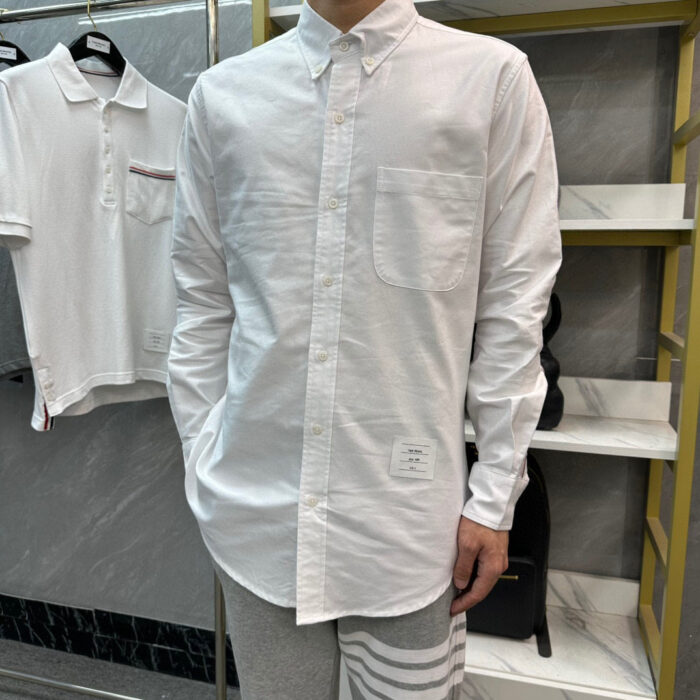 Camicia bianca a maniche lunghe, stile casual elegante, donna in negozio moda moderna.