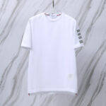 T-shirt bianca minimalista con dettagli sportivi e tocco rosso al collo, ideale per stile casual.