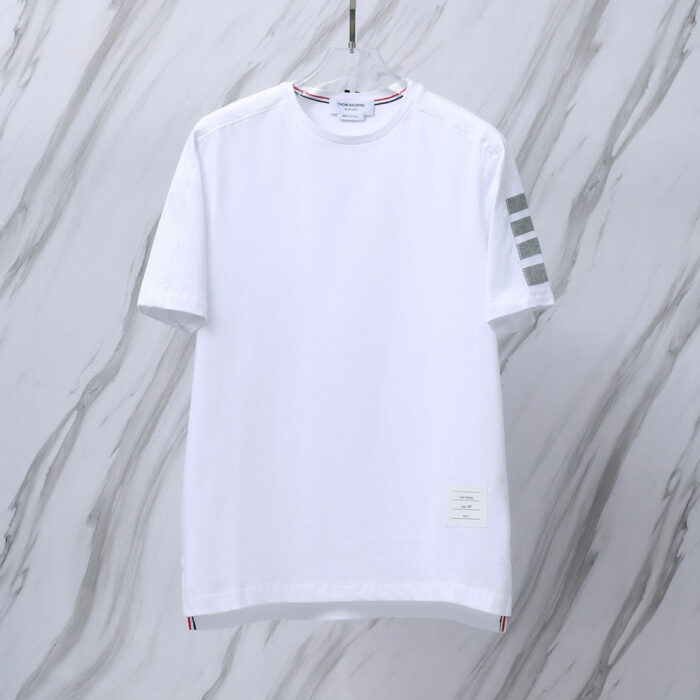 T-shirt bianca minimalista con dettagli sportivi e tocco rosso al collo, ideale per stile casual.