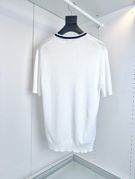 Camicia bianca minimalista con dettaglio blu navy sul collo, stile elegante e versatile.