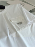 Camicia bianca minimalista con logo metallico, design elegante e versatile per ogni occasione.