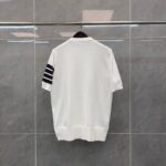 T-shirt bianca minimalista con maniche a righe nere, ideale per uno stile casual e sportivo.