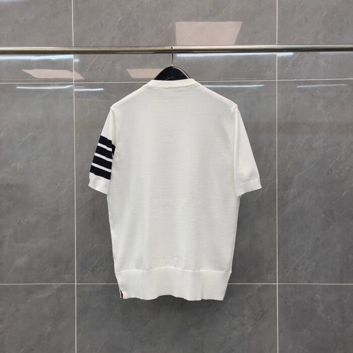 T-shirt bianca minimalista con maniche a righe nere, ideale per uno stile casual e sportivo.