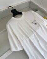 Maglietta bianca casual con tasca e etichetta, stile semplice e versatile.
