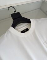 T-shirt bianca Fendi minimalista in cotone di lusso su gruccia nera.