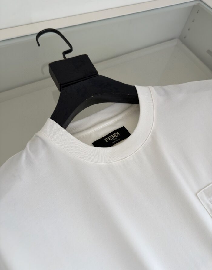 T-shirt bianca Fendi minimalista in cotone di lusso su gruccia nera.