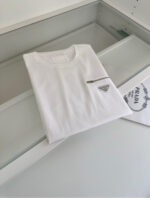 T-shirt bianca minimalista con zip e logo in pelle di lusso, stile elegante e casual.