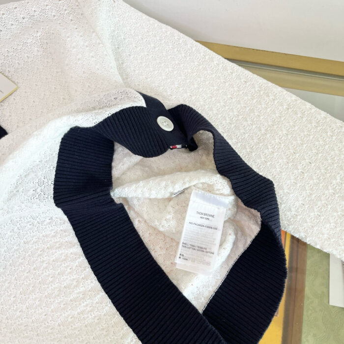 Maglione bianco in tessuto a scacchi con colletto navy, stile casual e raffinato.