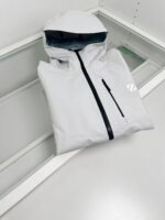 Giacca leggera grigia con cappuccio, zip nero e stile minimalista, ideale per outdoor e urban outdoor