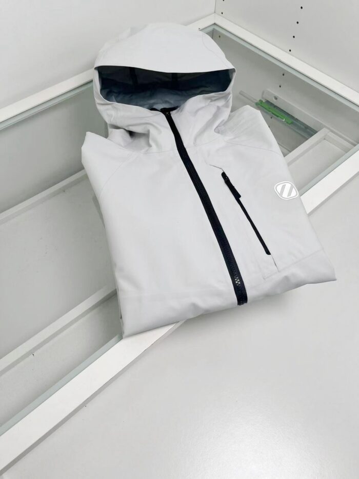 Giacca leggera grigia con cappuccio, zip nero e stile minimalista, ideale per outdoor e urban outdoor