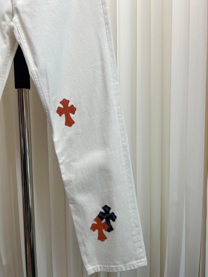 Pantaloni bianchi con cross colorati, stile moderno, casual e trendy, su gruccia in ambiente elegante.