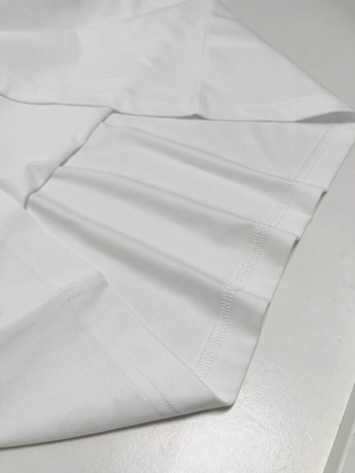 Manica di camicia bianca elegante, dettaglio sartoriale e riflessi di qualità, stile professionale.