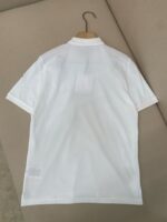 Maglietta polo bianca elegante con colletto strutturato, maniche corte e cuciture alle spalle.
