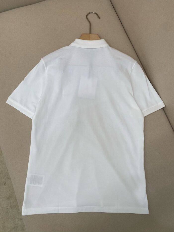 Maglietta polo bianca elegante con colletto strutturato, maniche corte e cuciture alle spalle.