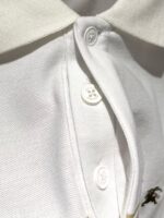 Polo bianca con colletto strutturato, bottoni classic e dettaglio ricamato elegante.