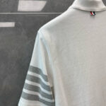 Maglietta polo bianca con dettagli grigi, stile elegante e sportivo, ideale per look casual e sofisticati.