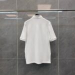 Maglietta polo bianca classica su gancio moderno, perfetta per look casual ed elegante.