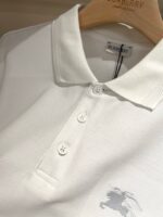 Maglietta polo bianca elegante con logo cavallo, tessuto morbido, su gruccia di legno.