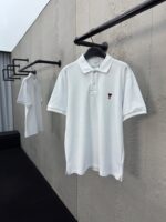 Polo bianca minimalista su parete industriale con ricamo elegante e stile moderno sofisticato.