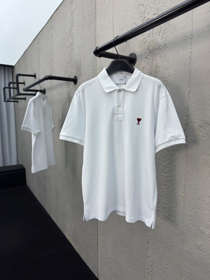 Polo bianca minimalista su parete industriale con ricamo elegante e stile moderno sofisticato.