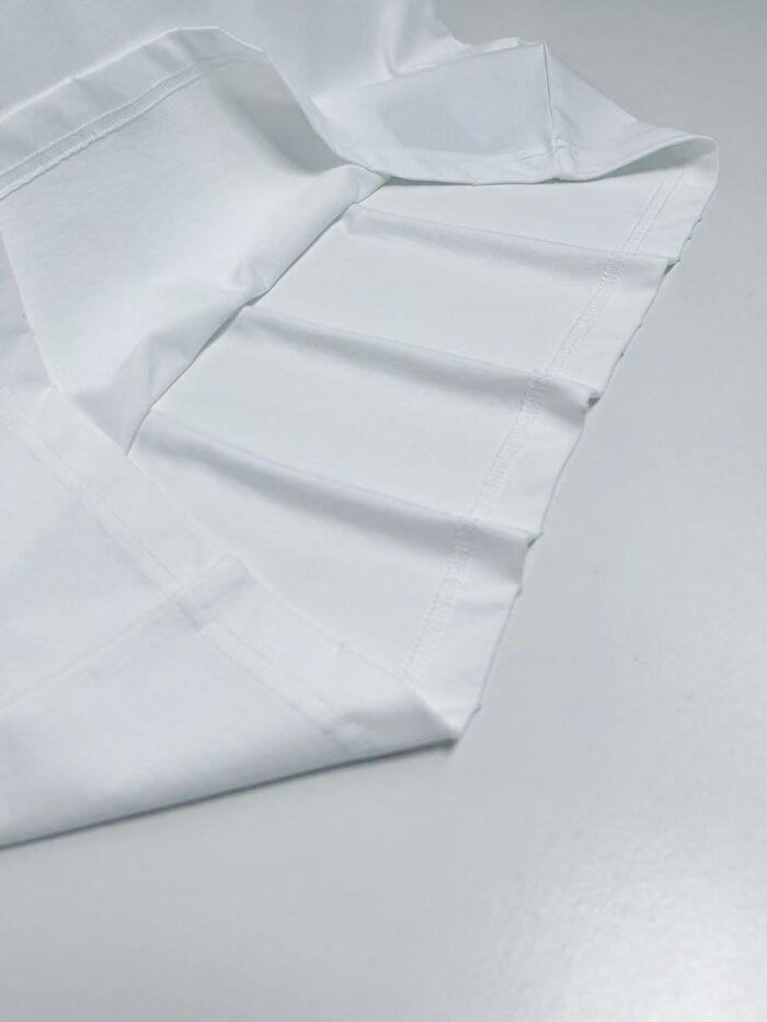 Camicia bianca elegante con colletto classico, tessuto liscio e finiture precise.