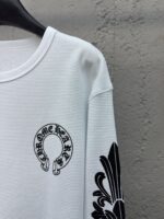 Camicia bianca con logo Chrome Hearts, dettagli neri e design floreale elegante.