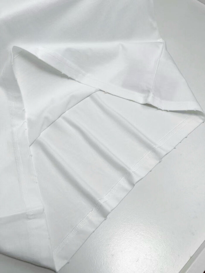Tessuto bianco liscio con pieghe eleganti, perfetto per abbigliamento e decorazioni raffinate.