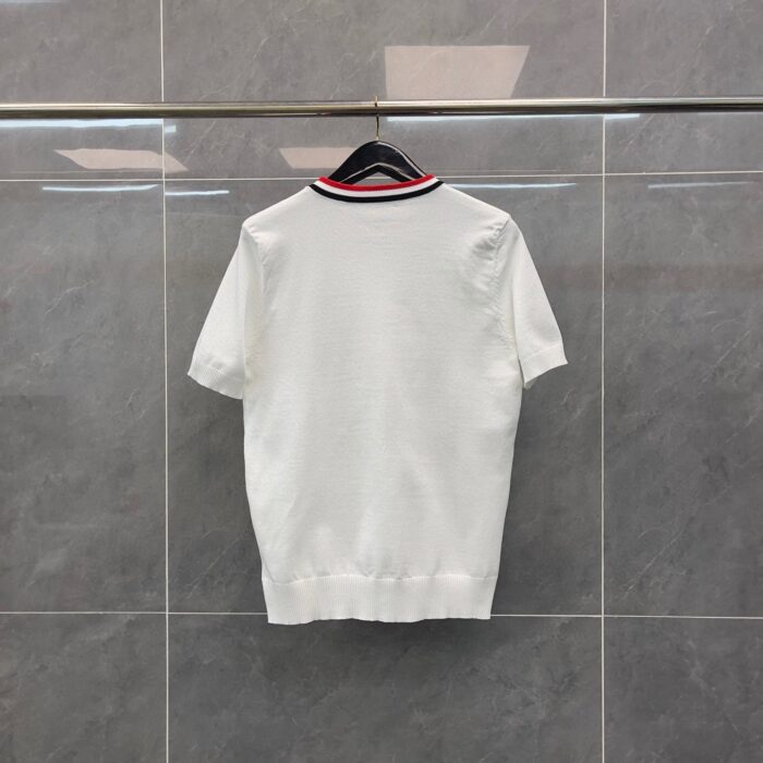 Camicia bianca con colletto a strisce rossa e nera, stile sportivo, su sfondo moderno.