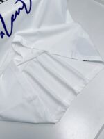 Camicia bianca elegante con logo blu cursivo, dettagli raffinati e tessuto di alta qualità.