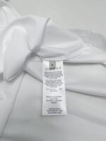 Camicia bianca con etichetta di cura, elegante e di alta qualità, ideale per occasioni formali.