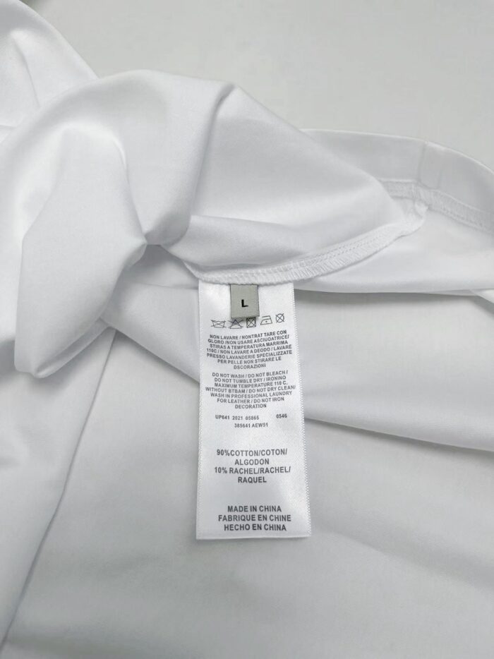 Camicia bianca con etichetta di cura, elegante e di alta qualità, ideale per occasioni formali.