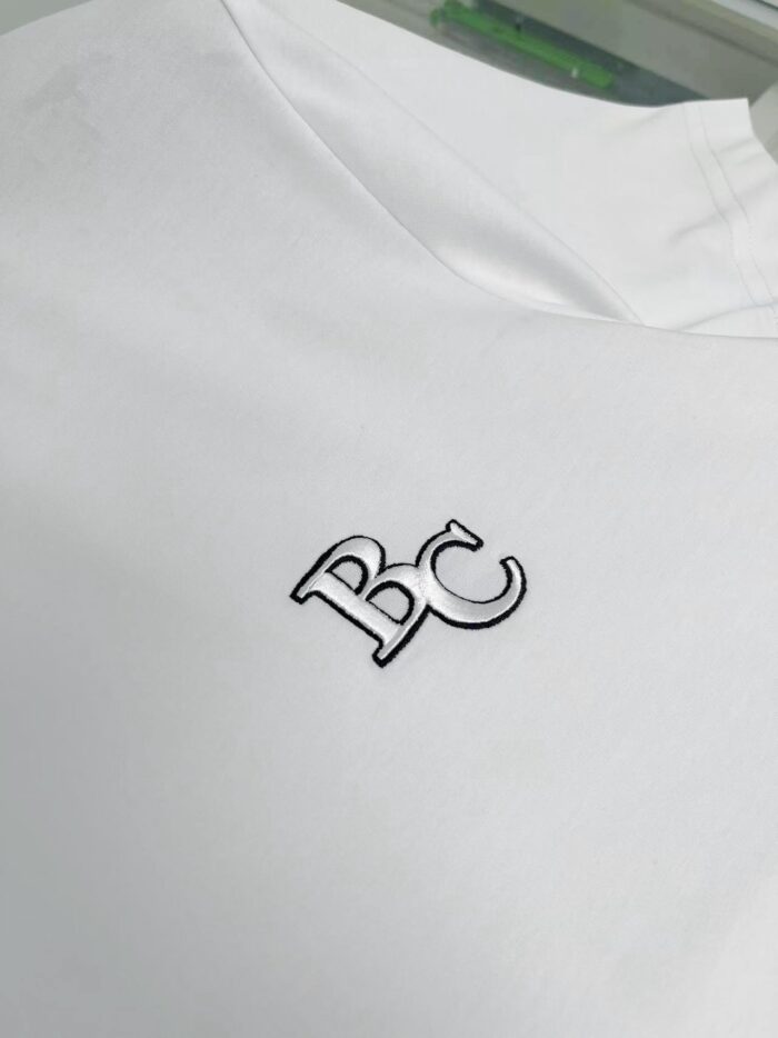 Maglietta bianca con logo ricamato nero, stile minimalista e di alta qualità.