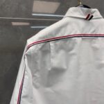 Camicia bianca elegante con dettaglio a contrasto sul colletto e piping raffinato.