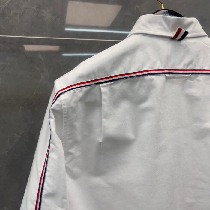 Camicia bianca elegante con dettaglio a contrasto sul colletto e piping raffinato.