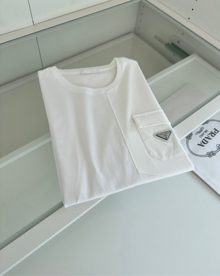 Maglietta bianca minimalista su superficie di vetro, elegante e versatile per ogni occasione.
