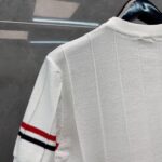 Camicia bianca con dettagli a strisce rosse e nere, stile casual elegante, tessuto elasticizzato.