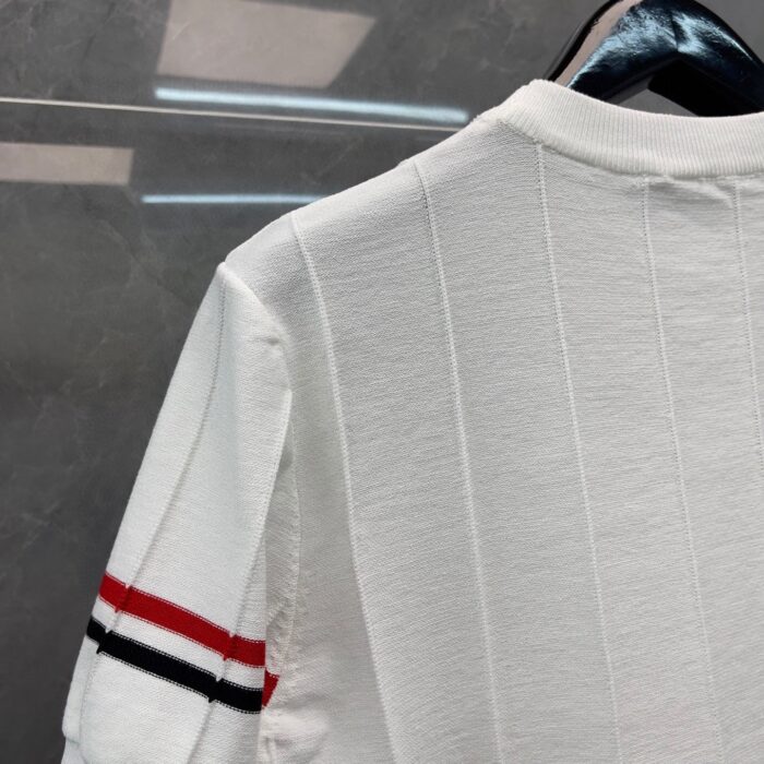 Camicia bianca con dettagli a strisce rosse e nere, stile casual elegante, tessuto elasticizzato.