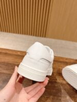 Sneaker bianca minimalista in mano, stile elegante e versatile per look casual e moderni.