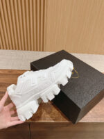 Sneaker bianca di lusso con design moderno, silhouette chunky e packaging elegante in stile contemporaneo.