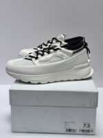 Sneakers bianche moderne con dettagli neri, su scatola bianca con taglia 7.5 visibile.