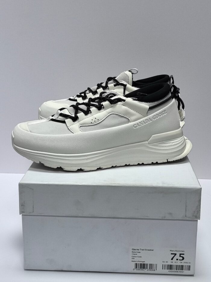 Sneakers bianche moderne con dettagli neri, su scatola bianca con taglia 7.5 visibile.