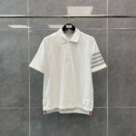 Maglietta polo bianca con dettagli sportivi, strisce sulle maniche e logo discreto.