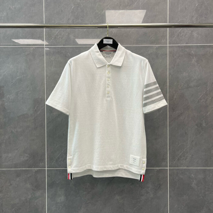 Maglietta polo bianca con dettagli sportivi, strisce sulle maniche e logo discreto.