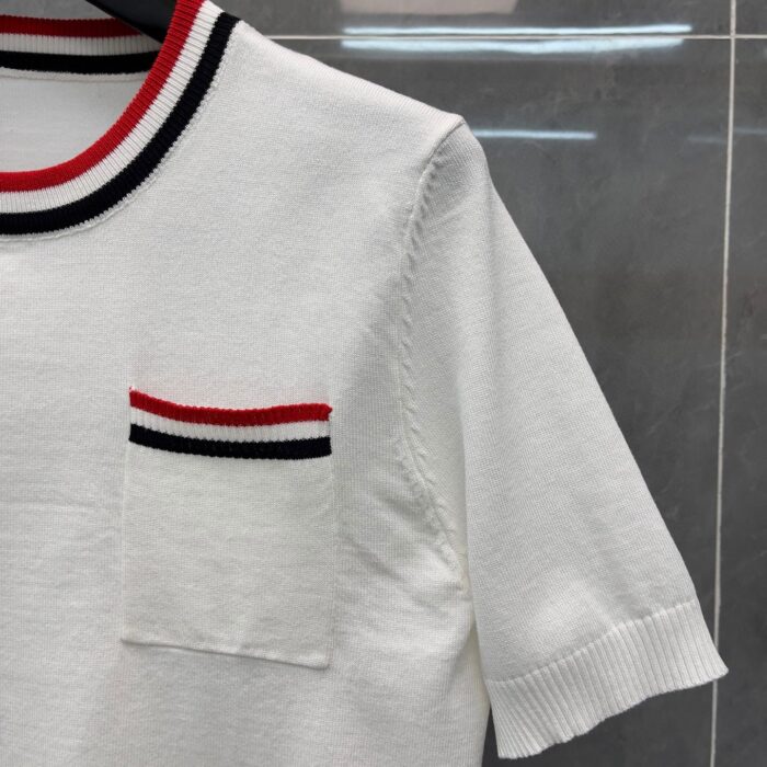 Camicia bianca estiva con colletto a righe e tasca abbinata, stile casual e moderno.