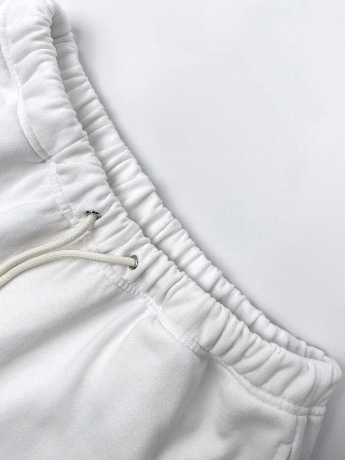 Pantaloni felpati bianchi con vita elastica e cordino regolabile per massimo comfort.